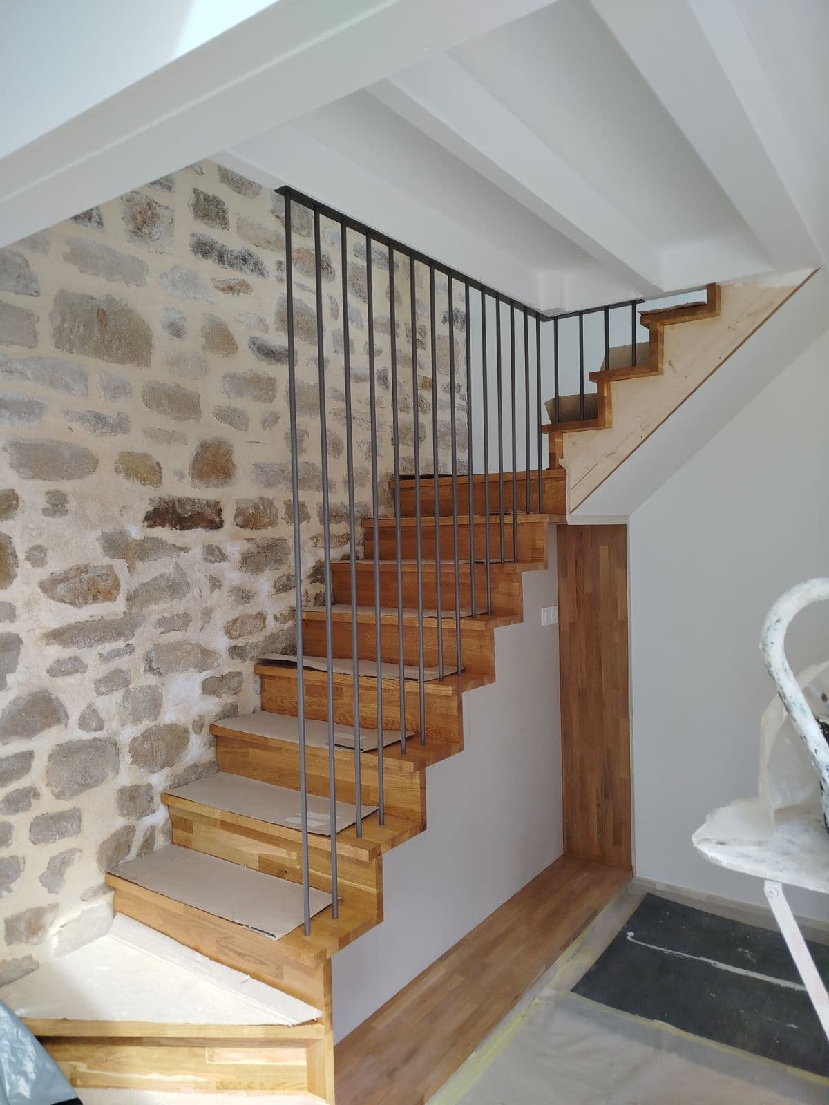 Escalier en bois avec garde-corps en barreau d'acier allant jusqu'au plafond