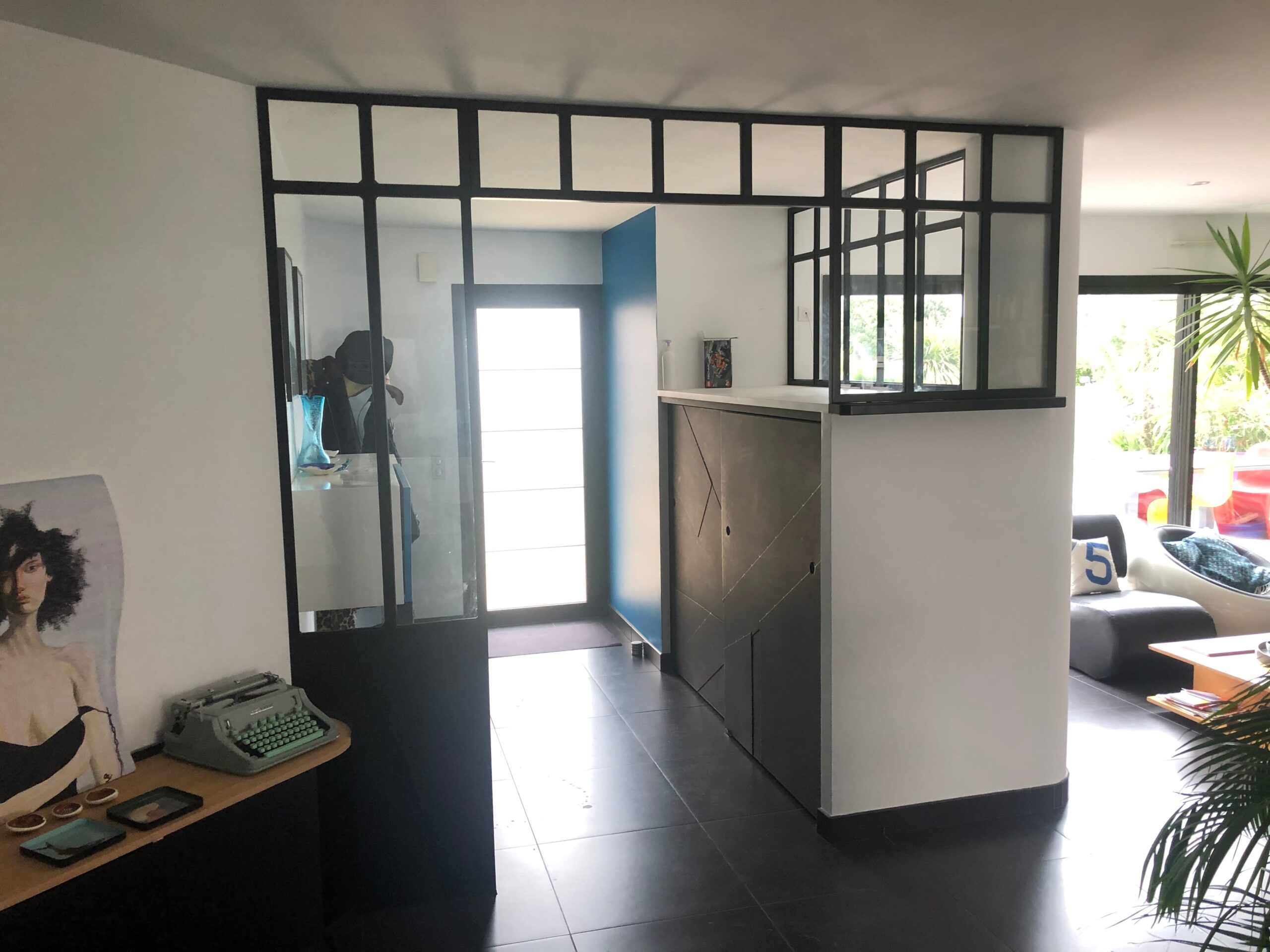 aménagement intérieur d'une cloison verrière noire dans l'entrée d'une maison.